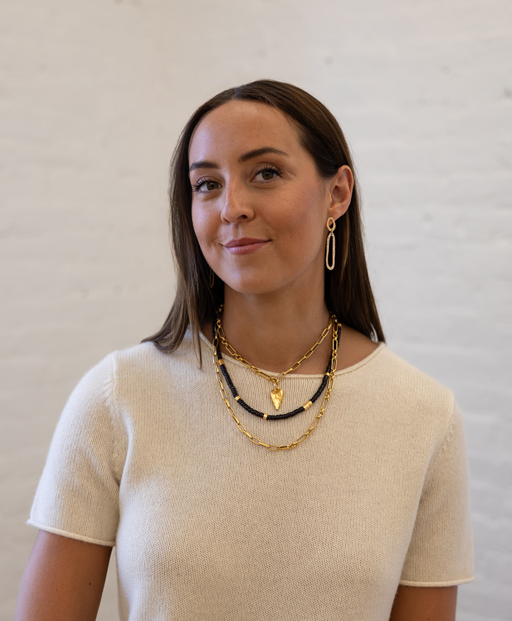 A model wearing a Hammered gold swirl with an oval cutout ear post.