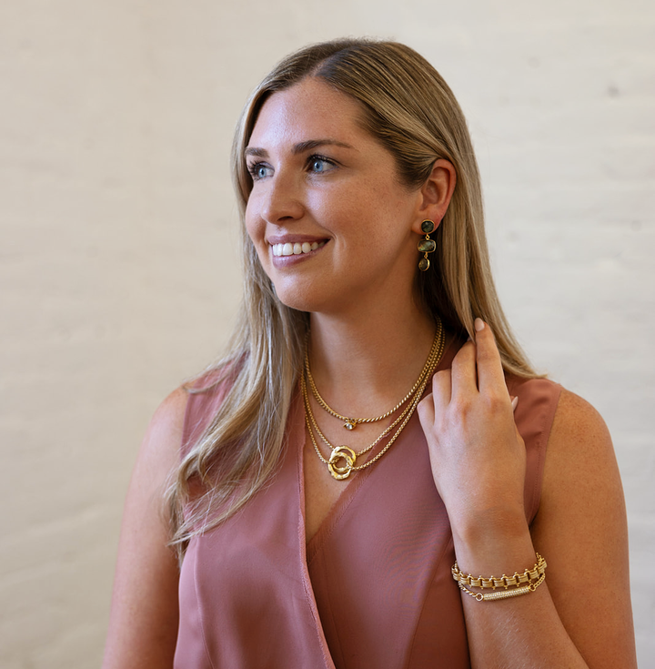 A model wearing a multi-tiered labradorite gemstone dangle post earring.