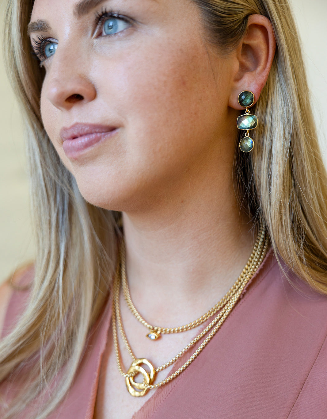 A model wearing a multi-tiered labradorite gemstone dangle post earring.