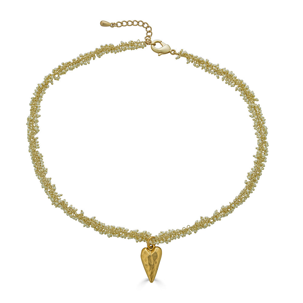 A seed pearl drizzle necklace with a hammered heart pendant