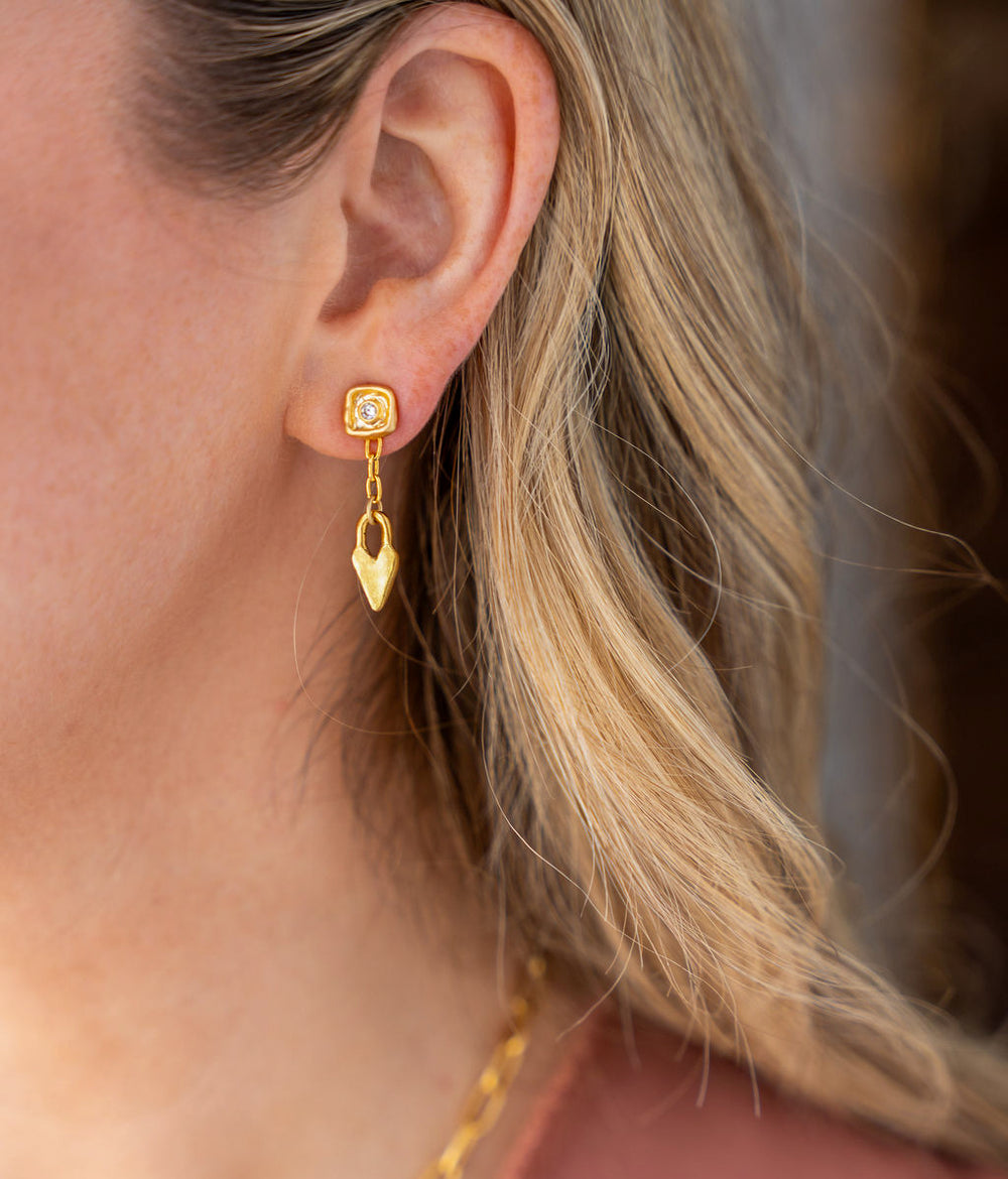 Gold dangle earrings with sculpted heart charms, chain link drop, and square stud tops with CZ accents.