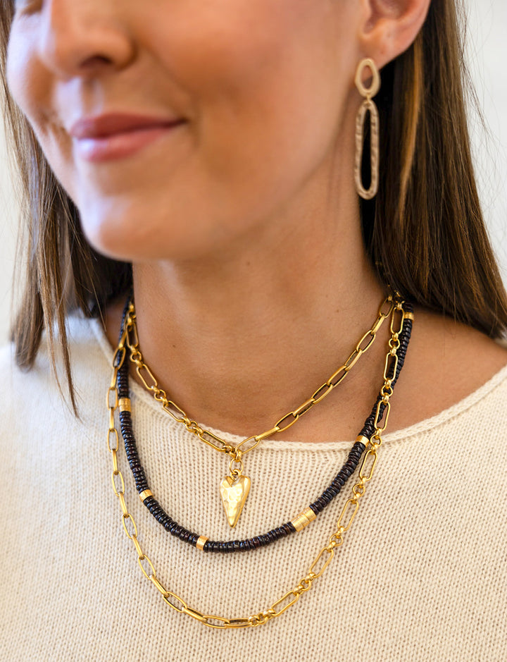 A model wearing a Hammered gold swirl with an oval cutout ear post.