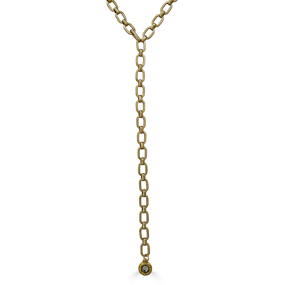 A matte gold lariat necklace with a crystal pendant.