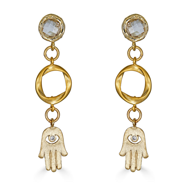 A pair of matte gold hamsa earring with circle connectors and crystal posts.