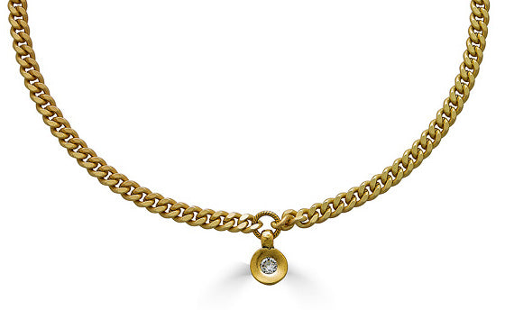 A modern round shaped crystal pendant on a flattened curb chain.