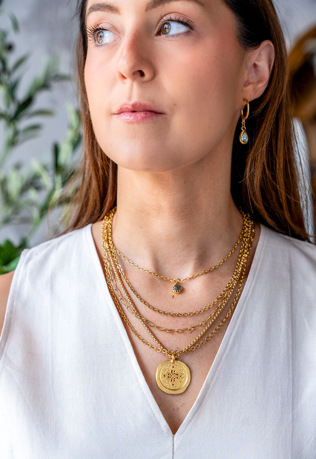 Matte gold coin necklace with filigree-etched round pendant on a rounded box chain.