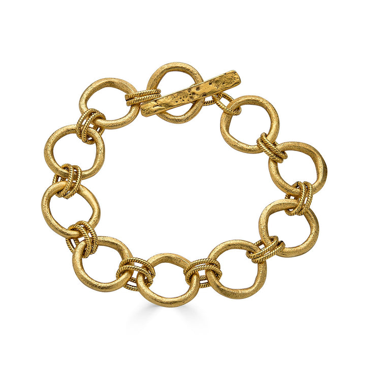 Gold bracelet featuring organic sculpted circle links with twisted rope details and a hammered toggle clasp.