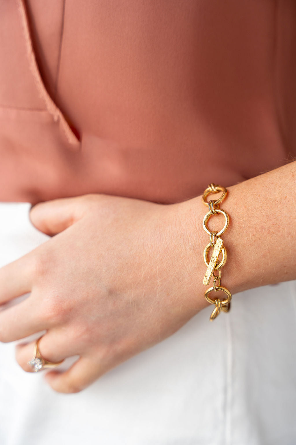 Gold bracelet featuring organic sculpted circle links with twisted rope details and a hammered toggle clasp.
