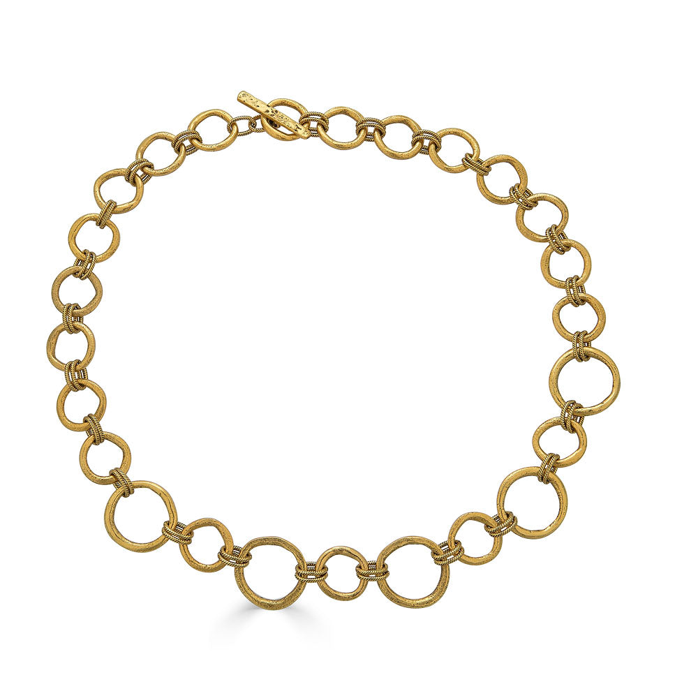 Matte gold sculpted circle necklace with textured round links and toggle clasp, styled three ways including lariat.