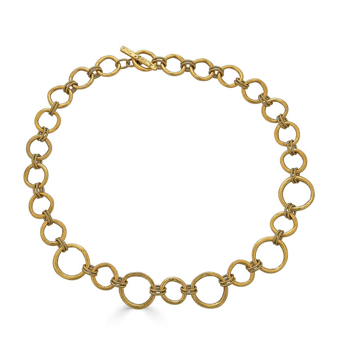 Matte gold sculpted circle necklace with textured round links and toggle clasp, styled three ways including lariat.
