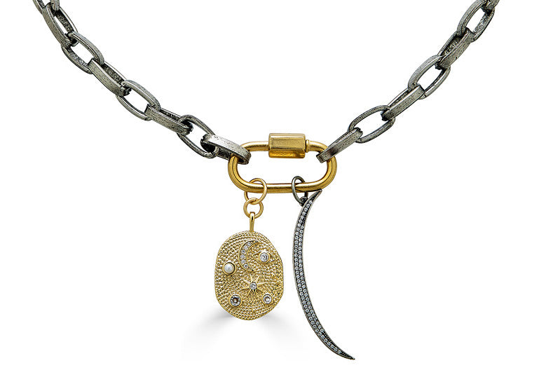 A thick silver paperclip necklace with a gold carabiner and moon and star charms.