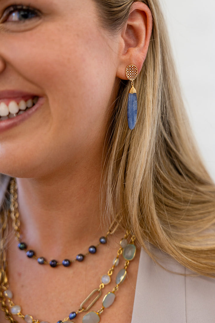 A kyanite dangle earring on an oval pave post