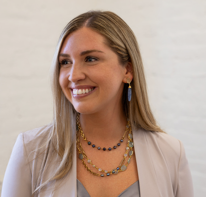A kyanite dangle earring on an oval pave post