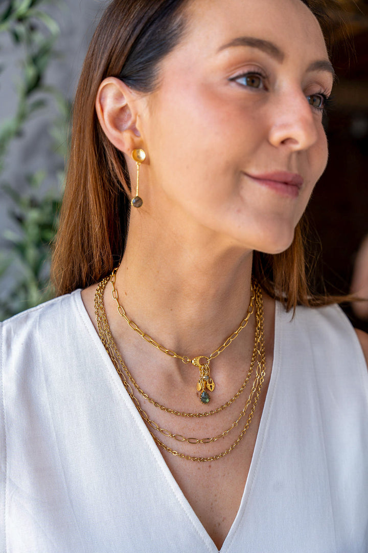 Gold drop earrings with hammered disc tops, textured vertical bars, and teardrop labradorite stones at the base.
