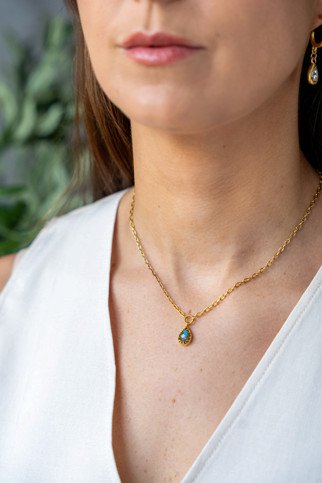 Gold chain necklace with a faceted teardrop labradorite pendant in a prong setting
