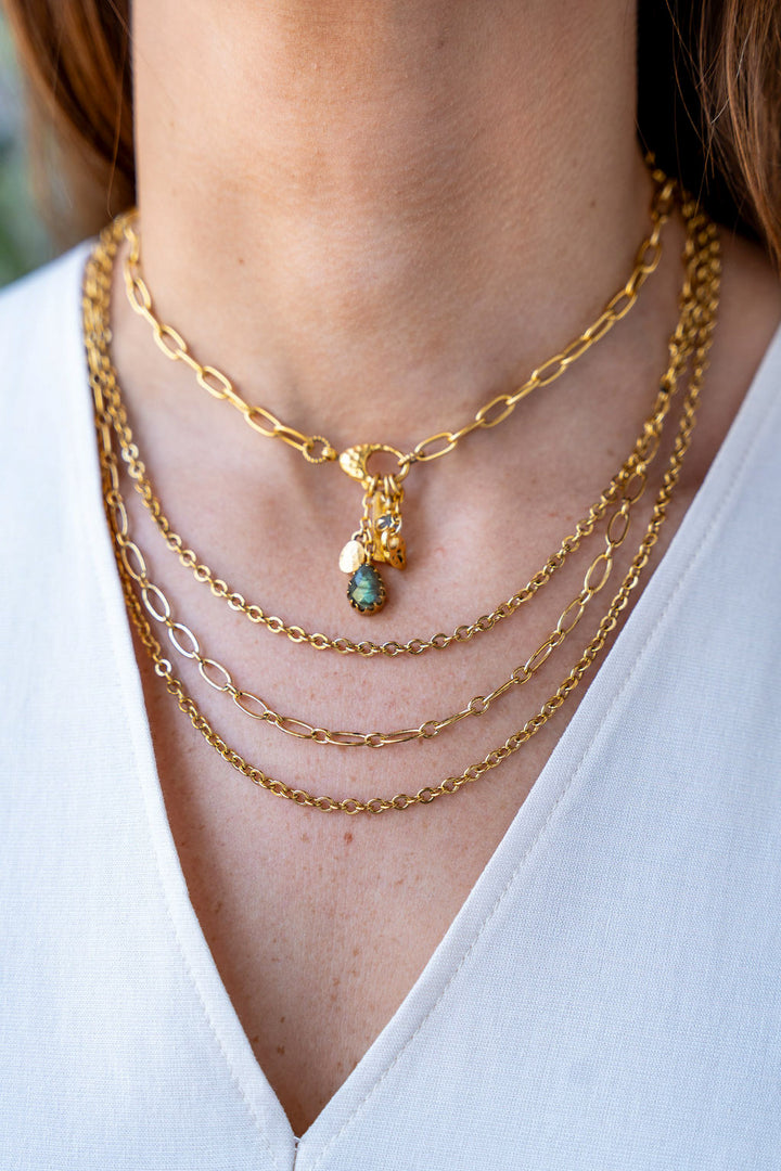 Gold three-strand necklace featuring delicate mixed chain styles and adjustable clasp