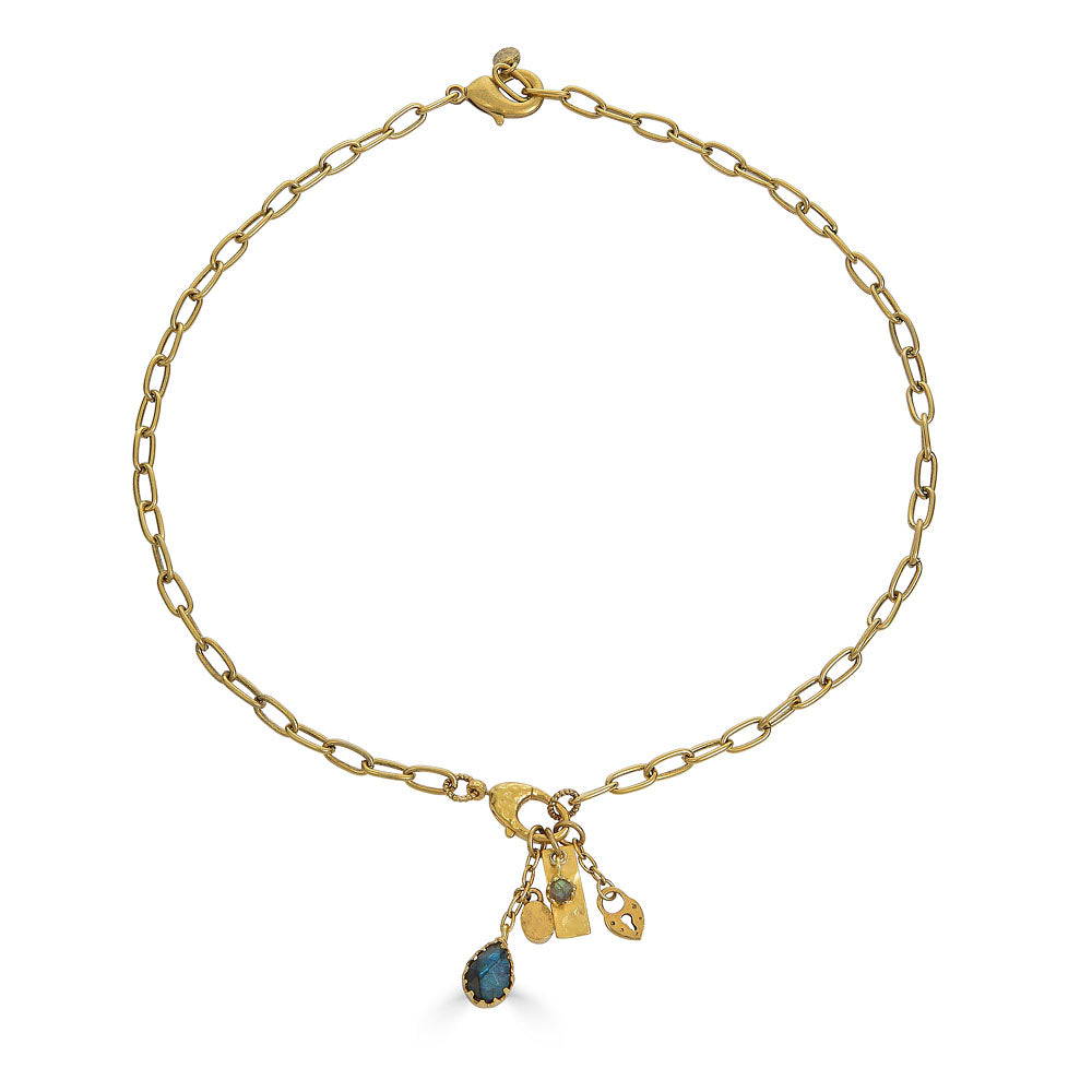 Gold chain necklace with a front clasp and dangling charms including a teardrop labradorite and textured gold talismans.