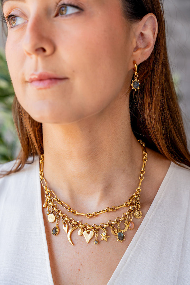 Gold hoop earrings with hammered finish and fixed oval labradorite charm framed by rounded prongs.