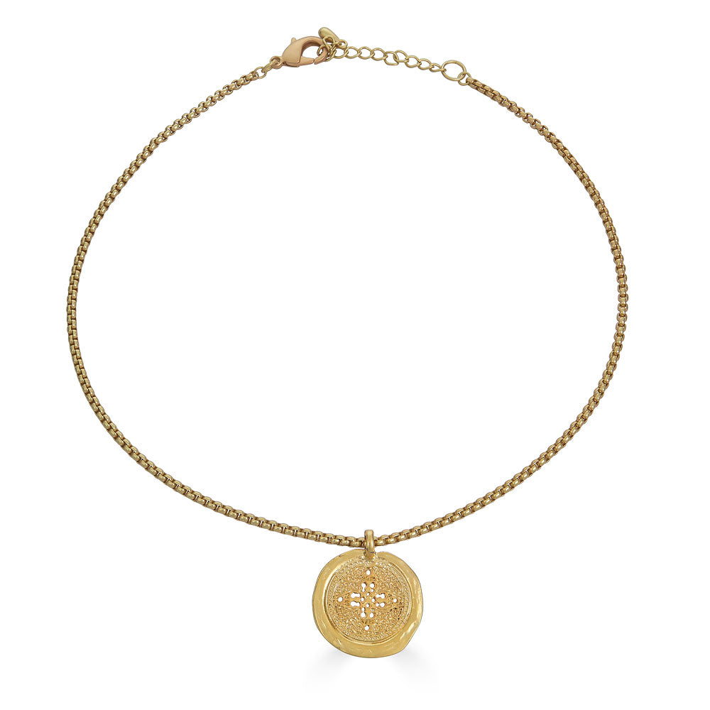 Matte gold coin necklace with filigree-etched round pendant on a rounded box chain.