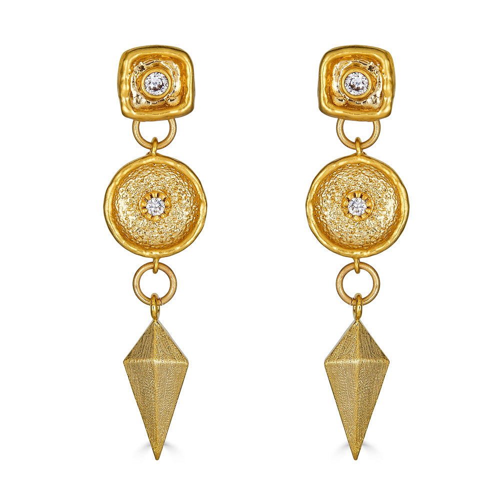 A matte gold dangle earring with a shield charm and a crystal connector. Post earrings with a crystal detail