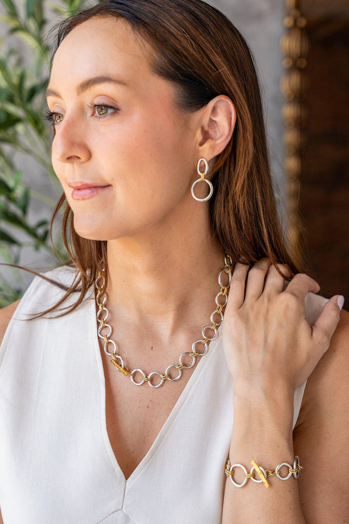 Mixed metal earrings with silver sculpted circles, soft gold oval tops, and rope-textured gold connector rings.