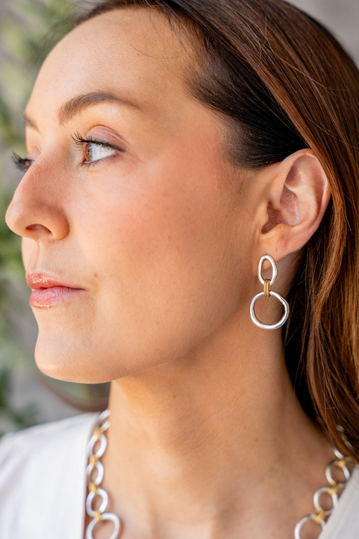 Mixed metal earrings with silver sculpted circles, soft gold oval tops, and rope-textured gold connector rings.