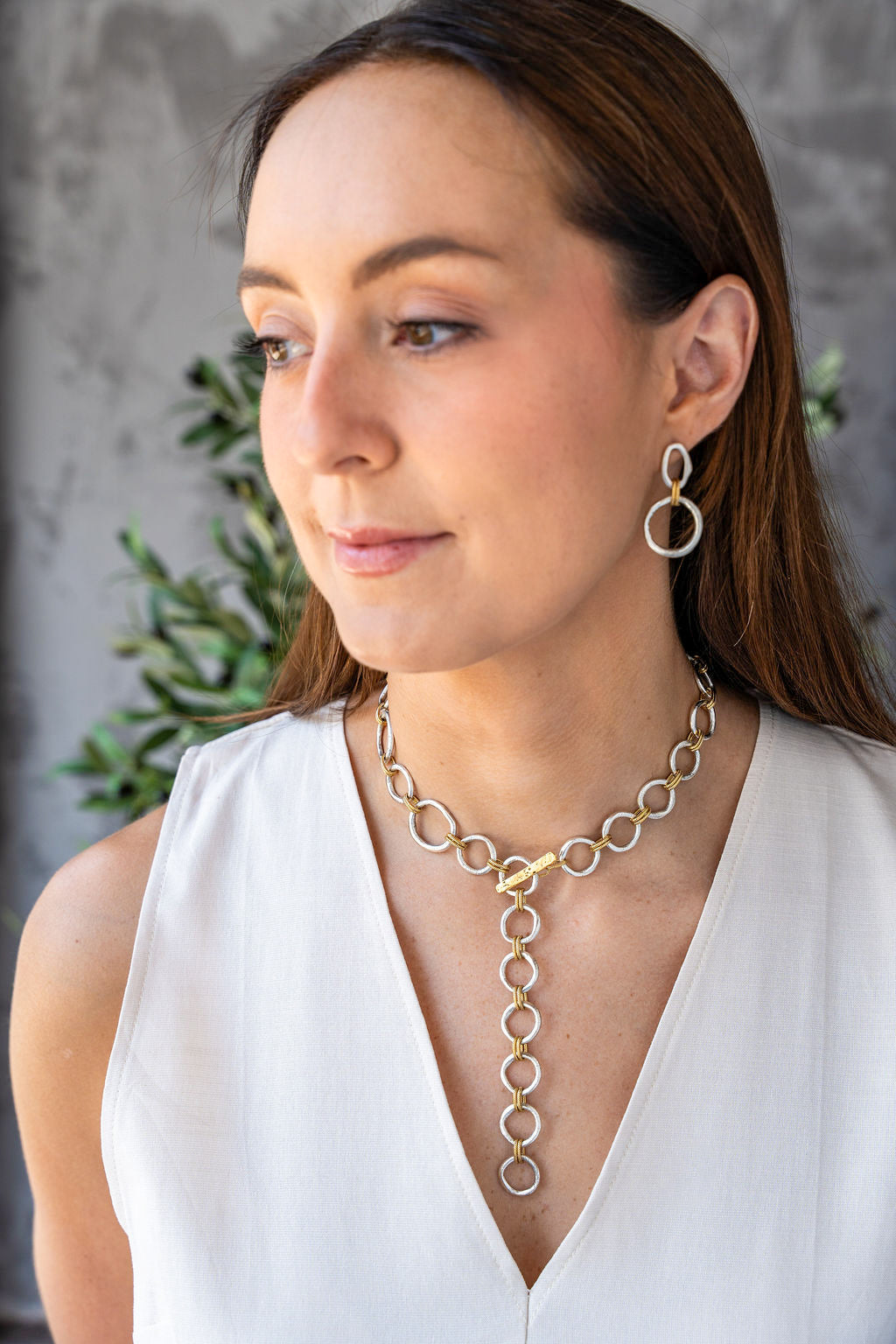 Mixed metal necklace with matte silver and gold sculpted circle links, toggle clasp, and rope-textured accents styled multiple ways.