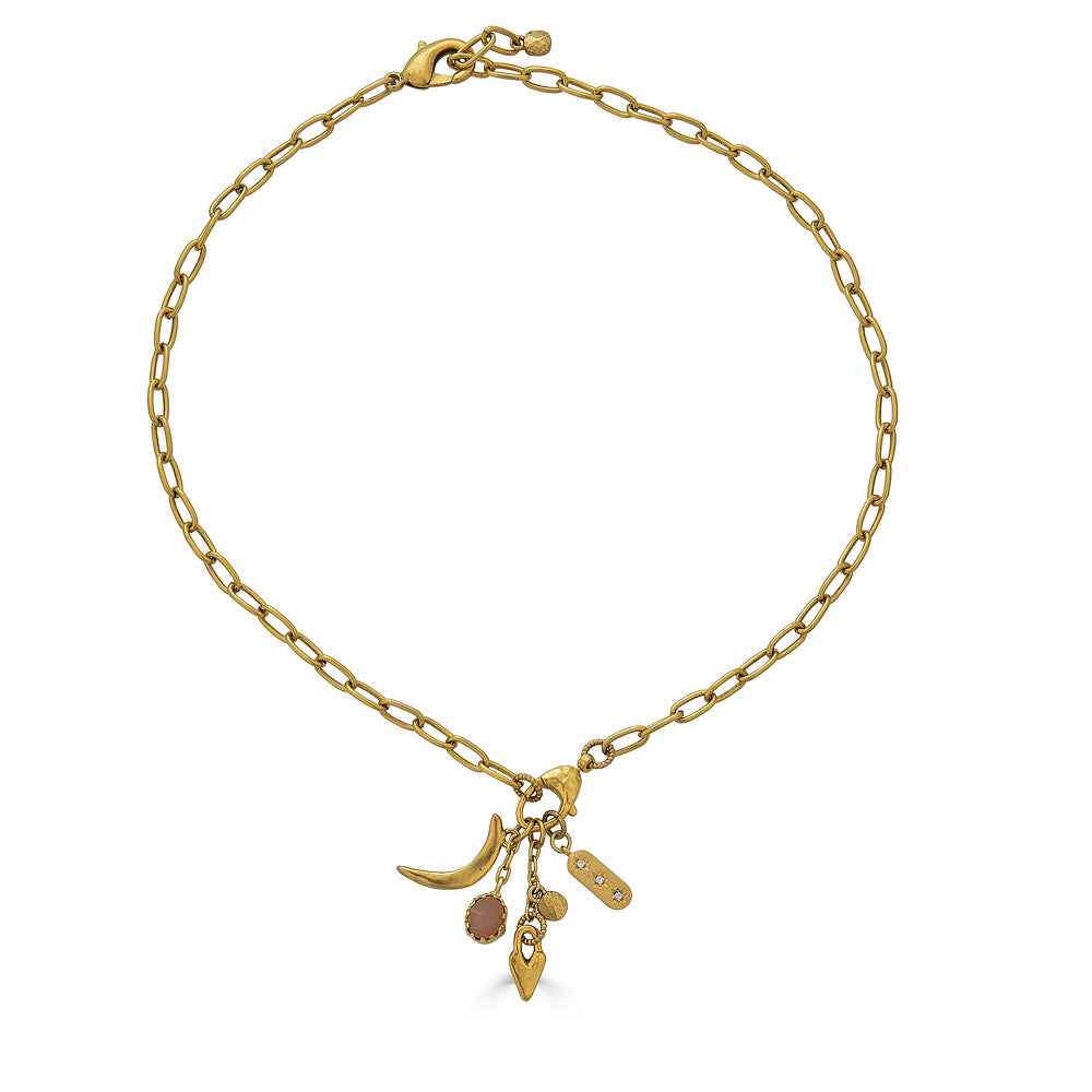 Gold necklace featuring a peach moonstone drop and charm cluster with crescent moon and heart details.