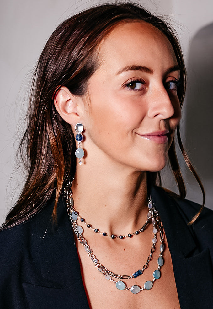 a model wearing A silver mixed gemstone necklace with chalcedony, kyanite, moonstone and pearls.