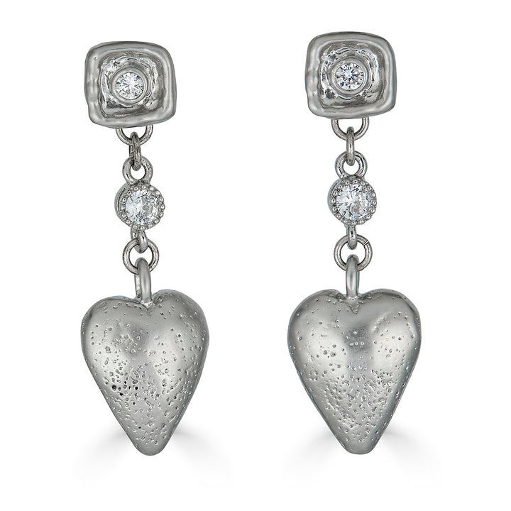 Silver drop earrings with textured puffed hearts and two bezel-set CZ stones on each earring.