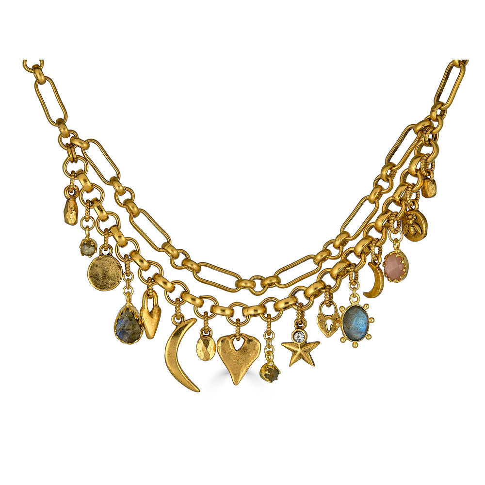 Gold charm necklace with layered chain and assorted symbolic charms including moons, hearts, stars, and gemstones.