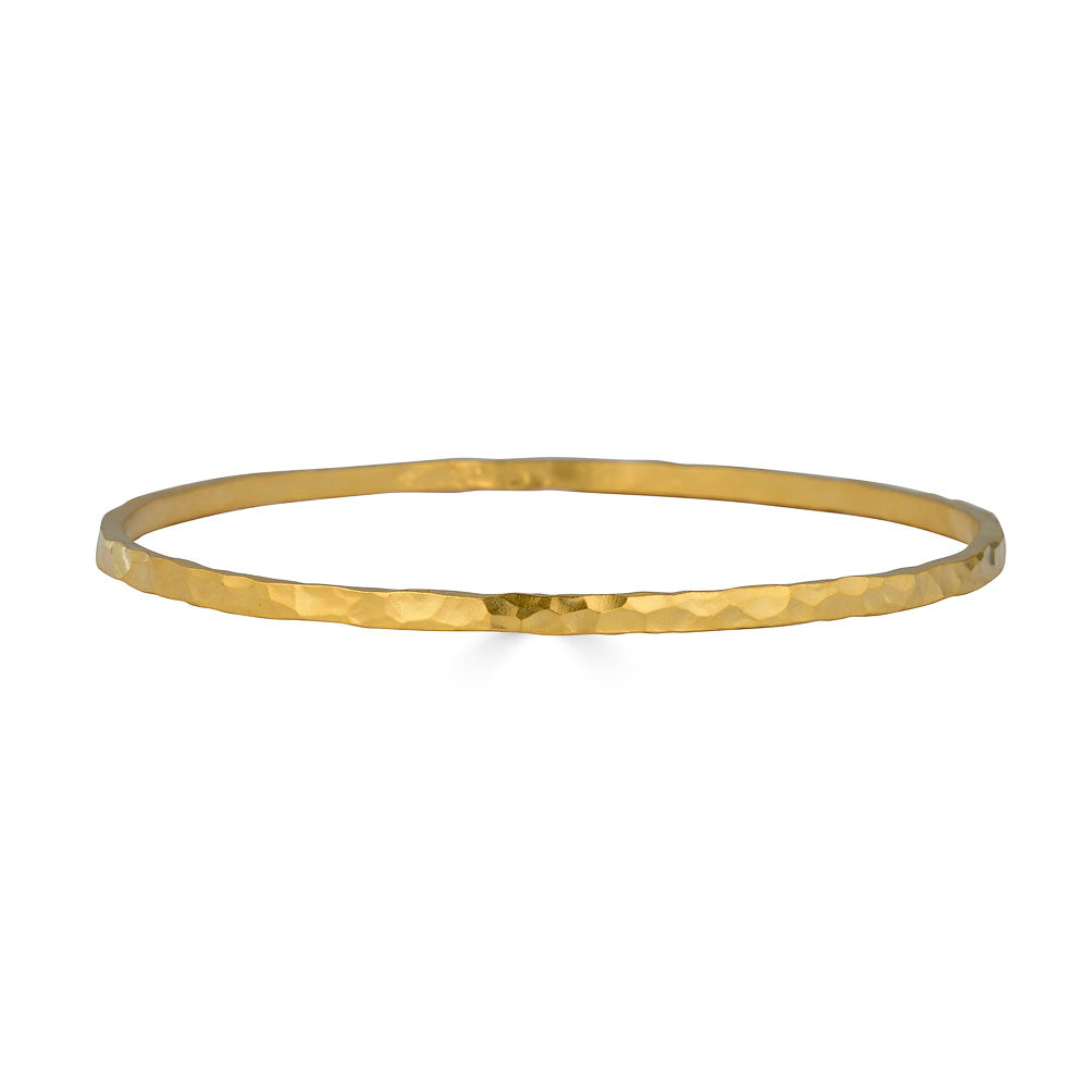 Wide hammered gold bangle bracelet with organic hand-forged texture.