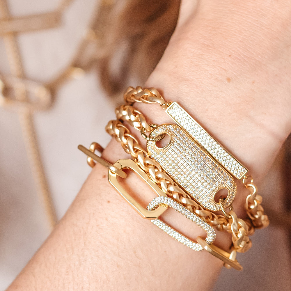 A woman's wrist modeling gold chainlink bracelets.