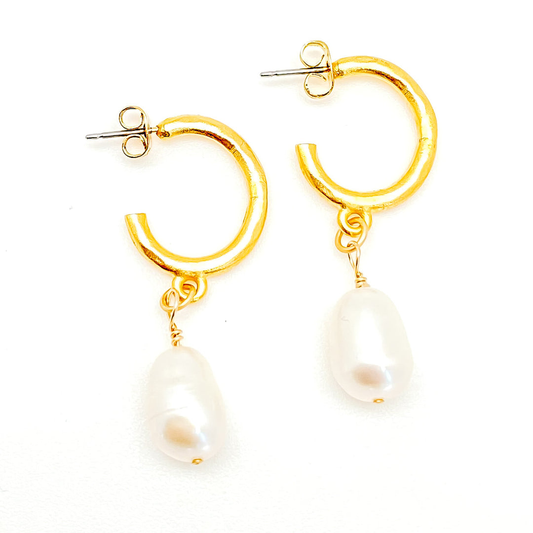 A pair of baroque pearl earrings on gold ear loops.