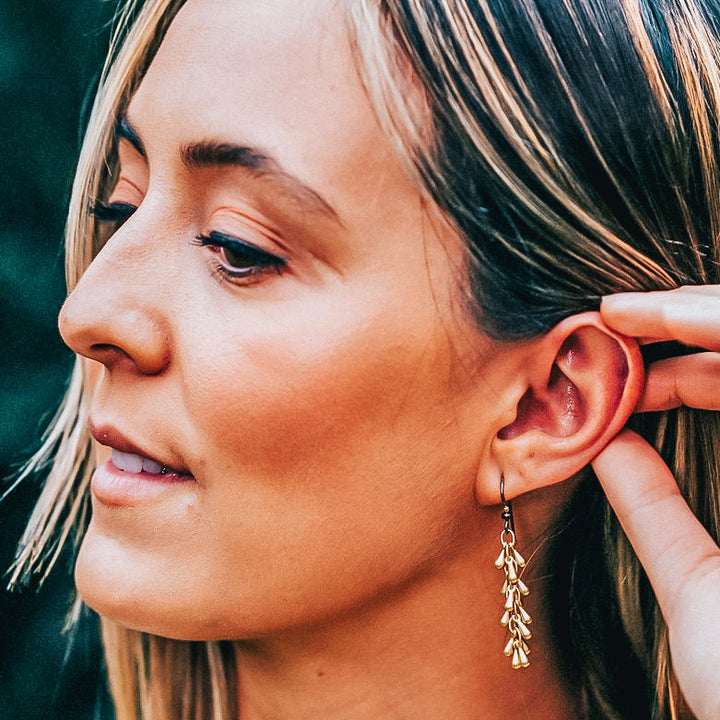 A model wearing a gold fireworks earring.