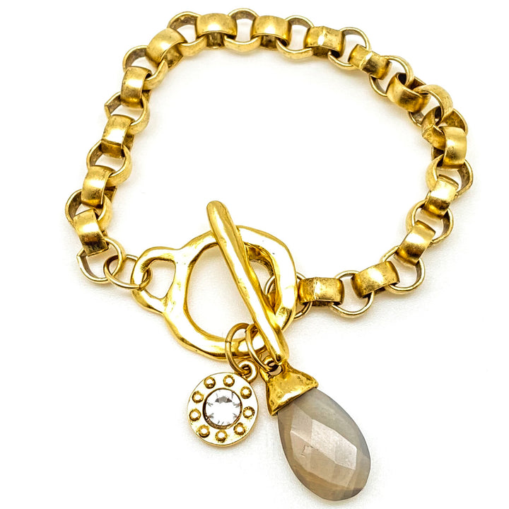 A gold chunky rolo chain bracelet with a labradorite charm and toggle clasp.