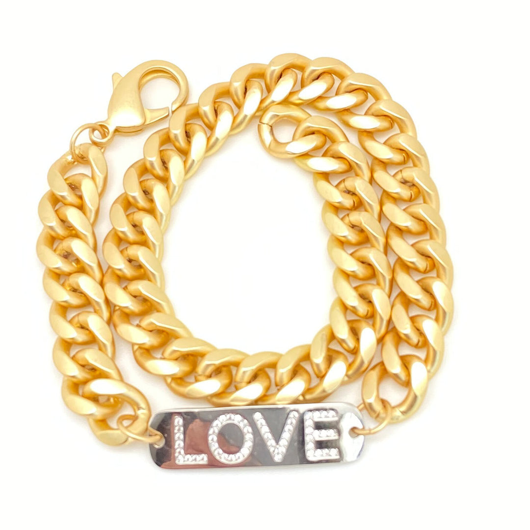 A matte gold chainlink bracelet with LOVE in CZS on silver tag.