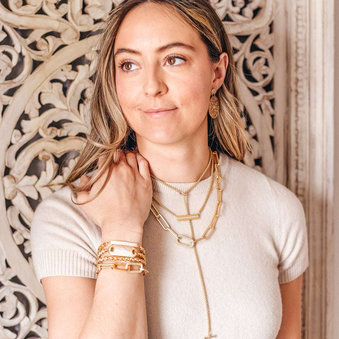A model wearing gold layered chainlink necklaces.