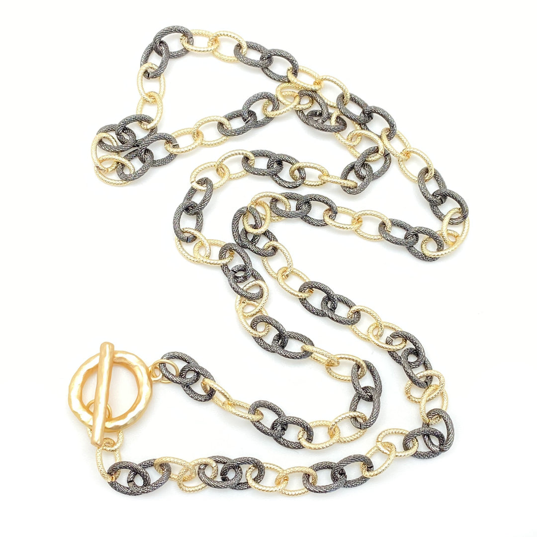 A mixed metal rhodium and gold necklace with toggle clasp.