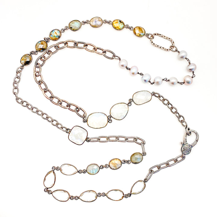 A silver mixed chain and gemstone necklace, with moonstone, labradorite, crystal, and pearl details.