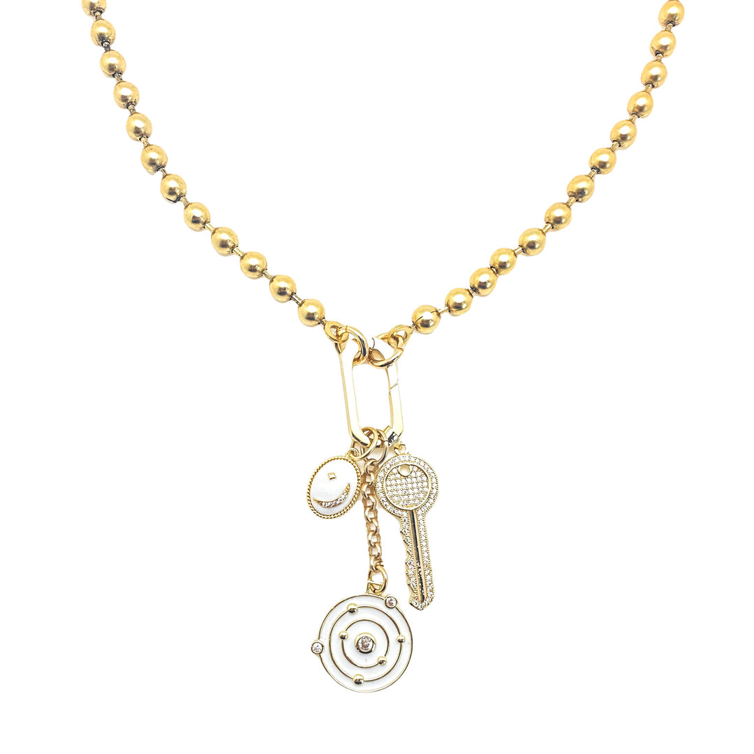 A gold ball chain necklace with white solar system, oval moon, and pave key charms.