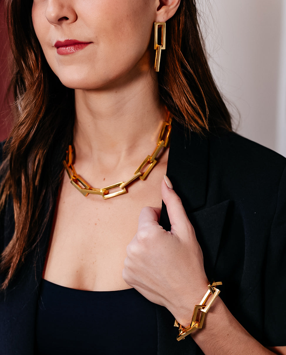 A model wearing A gold chunky rectangle link necklace with a pave clasp.