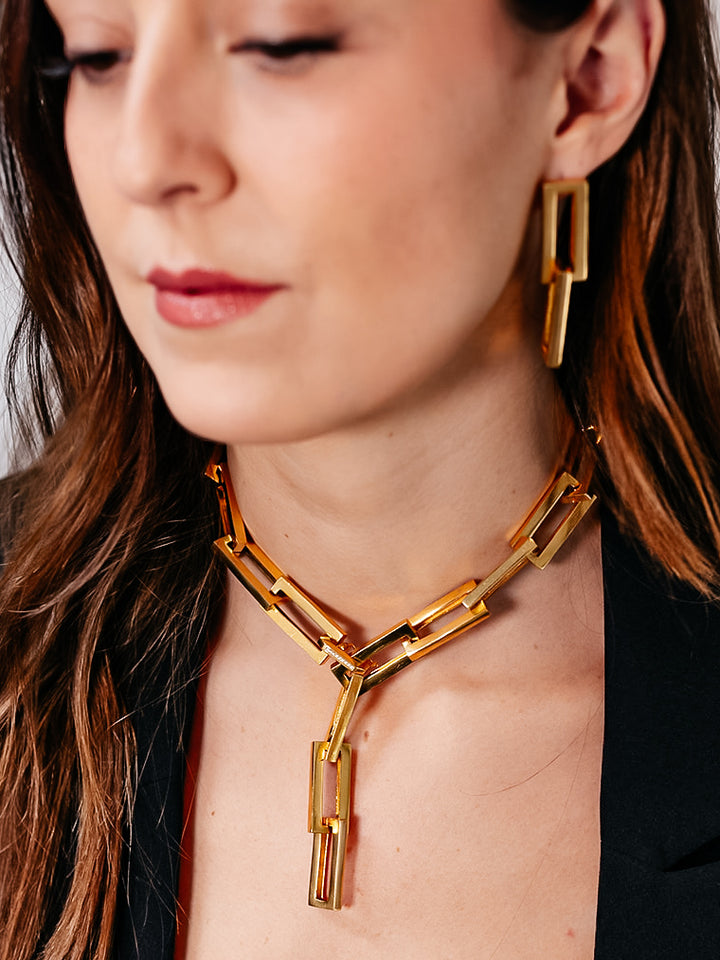 A model wearing A gold chunky rectangle link necklace with a pave clasp.