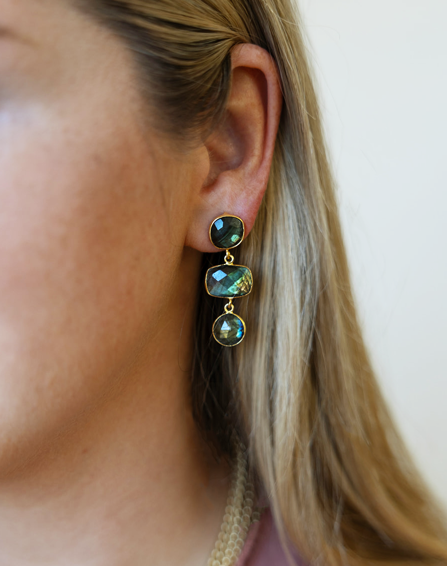 A model wearing a multi-tiered labradorite gemstone dangle post earring.