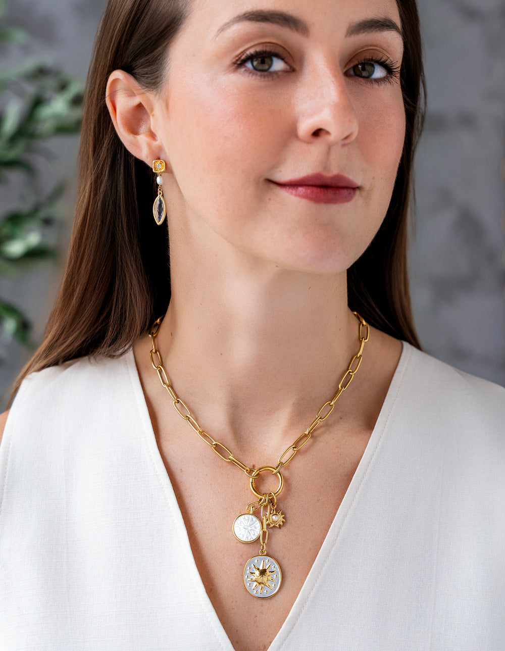 Gold paperclip chain necklace with enamel celestial charms, mother-of-pearl detail, and a sun medallion pendant.