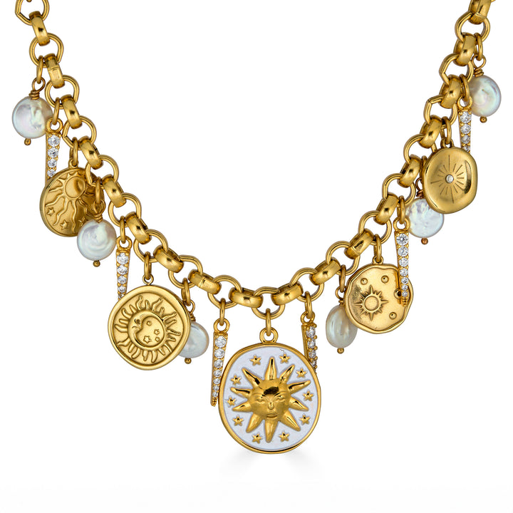 Gold celestial charm necklace with sun medallions, coin pearls, pavé crystal accents, and dangling celestial charms on a chunky chain.