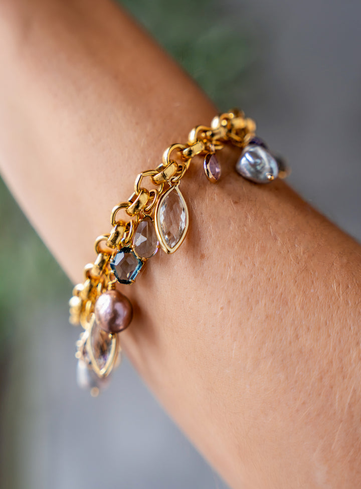 Gold chain charm bracelet with colorful faceted gemstones and iridescent freshwater pearl drops.