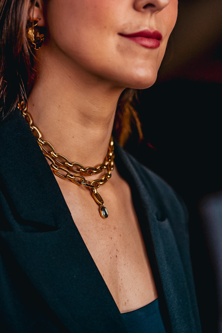 a model wearing a large hammered gold hoop earring.