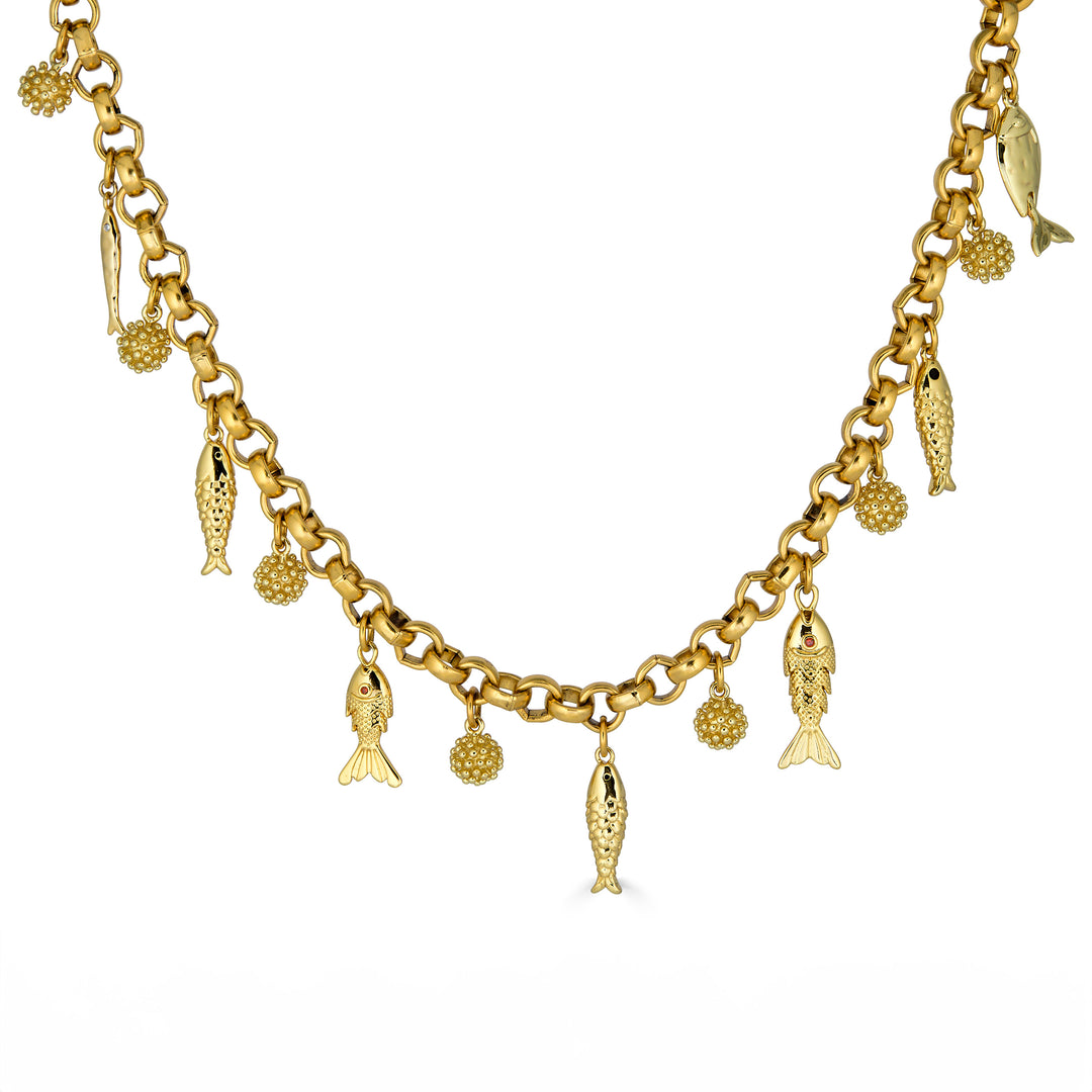 Convertible gold fish charm necklace with dangling fish and textured bead charms worn as both a lariat and classic chain necklace.