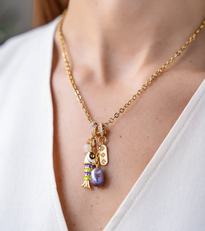 Gold charm necklace with enamel fish charm, freshwater pearl drop, and pavé accent charms on a delicate chain.